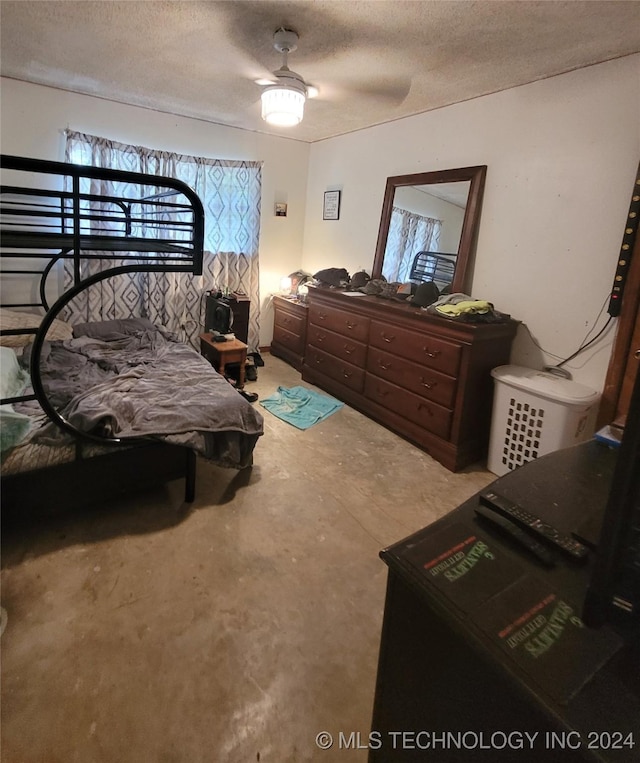 bedroom with a textured ceiling, ceiling fan, and concrete floors