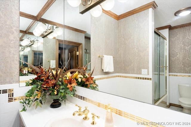 bathroom featuring sink, walk in shower, crown molding, toilet, and tile walls