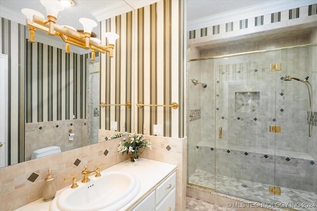 bathroom with decorative backsplash, crown molding, vanity, and a shower with shower door