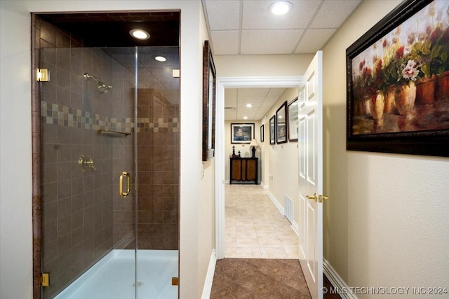 bathroom featuring tile patterned flooring, a paneled ceiling, and an enclosed shower