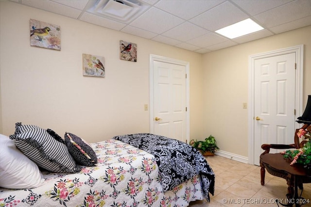 tiled bedroom featuring a paneled ceiling