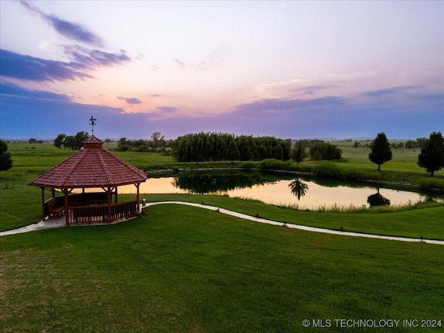 view of community with a gazebo, a lawn, and a water view