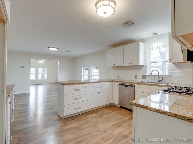 kitchen with kitchen peninsula, sink, pendant lighting, dishwasher, and white cabinetry