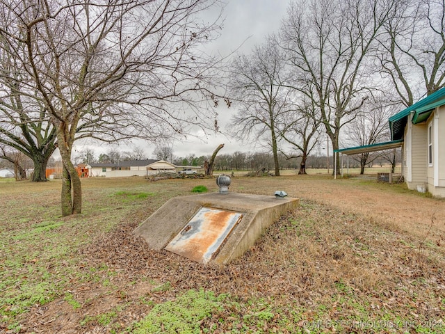 entry to storm shelter featuring a lawn