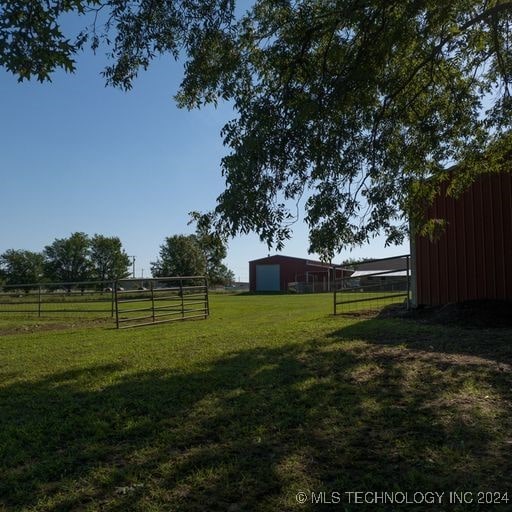 view of yard with a rural view and an outdoor structure