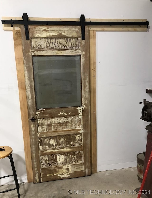 room details featuring a barn door and concrete floors