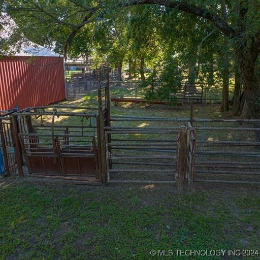 view of gate with a lawn and an outdoor structure