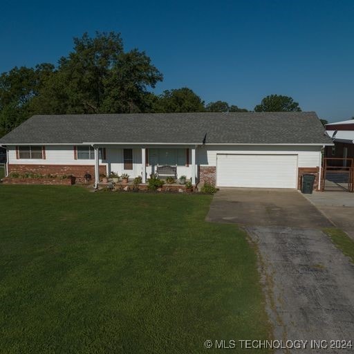 single story home featuring a garage and a front lawn