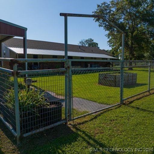 view of gate with a yard