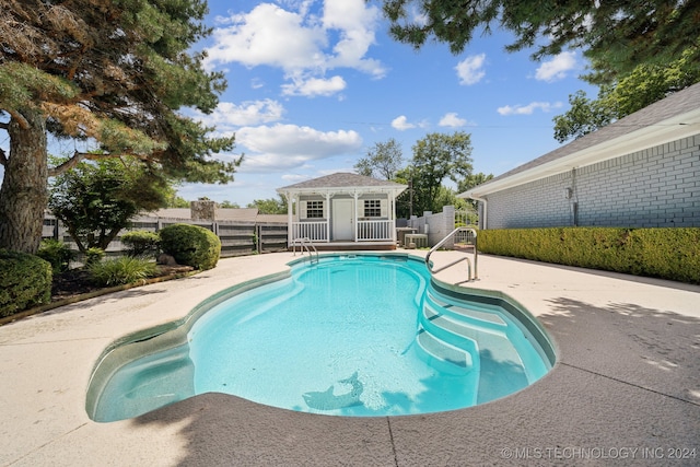 view of swimming pool featuring a patio and an outdoor structure