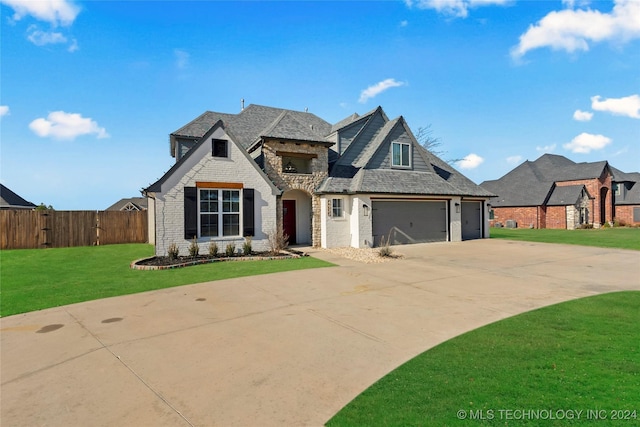 french provincial home featuring a garage and a front lawn