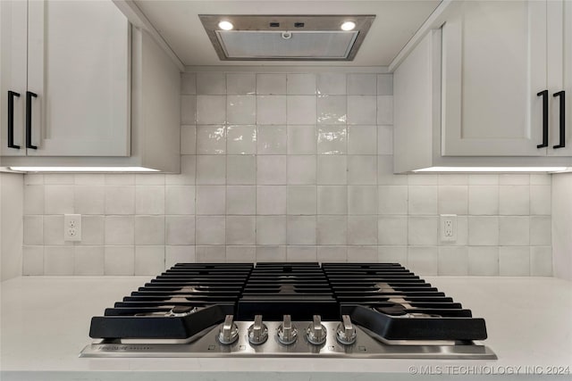 room details featuring white cabinets, backsplash, and stainless steel gas cooktop