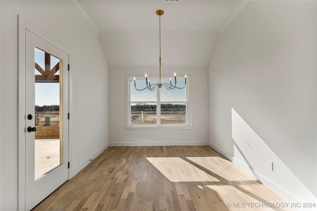 unfurnished dining area featuring light hardwood / wood-style flooring, a chandelier, and vaulted ceiling