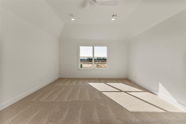 empty room with light carpet, vaulted ceiling, and ceiling fan