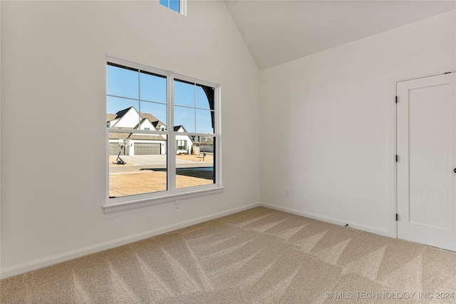 empty room featuring carpet and vaulted ceiling