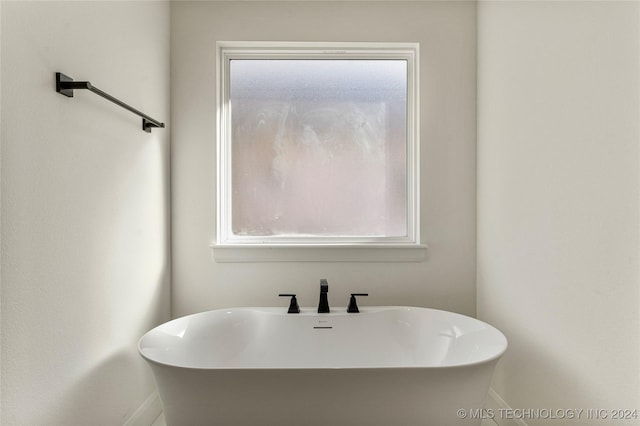 bathroom with a washtub and sink