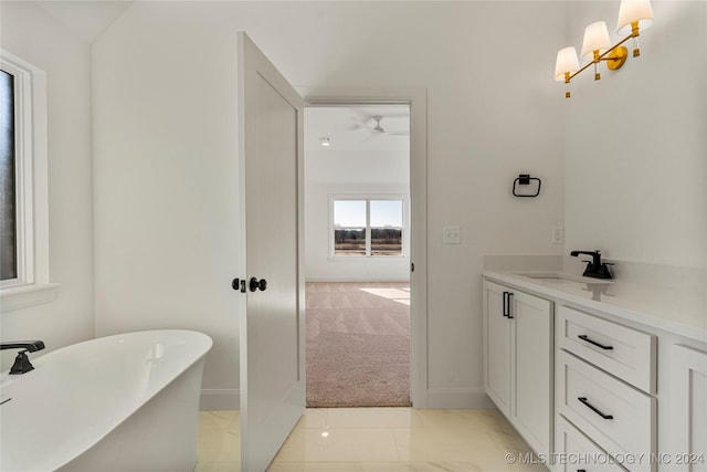 bathroom with tile patterned floors, vanity, ceiling fan, and a tub