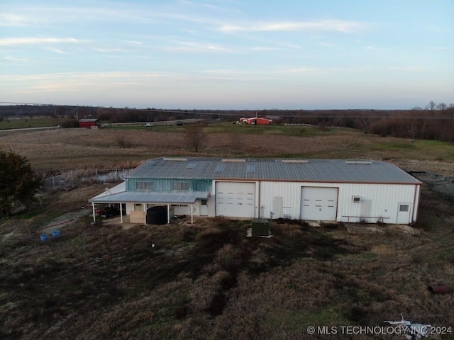 aerial view at dusk featuring a rural view