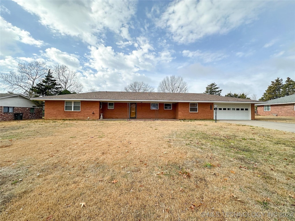 single story home featuring a garage and a front lawn