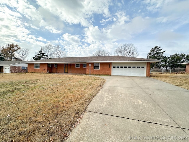 ranch-style house featuring a garage and a front lawn