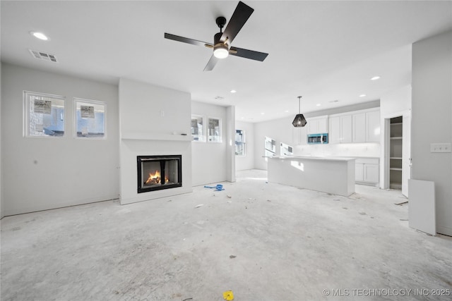 unfurnished living room with ceiling fan