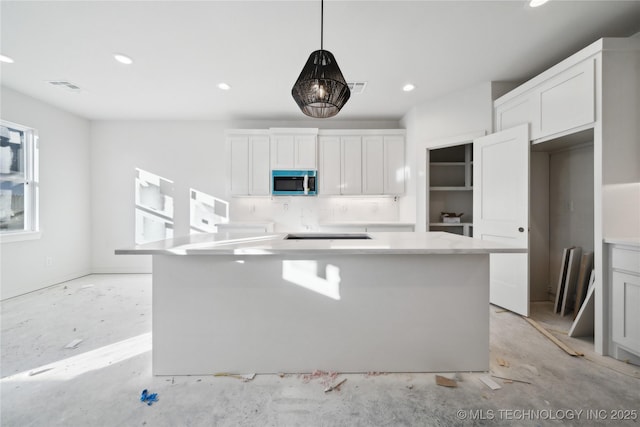 kitchen featuring white cabinetry, tasteful backsplash, hanging light fixtures, and a center island