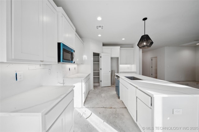 kitchen featuring decorative light fixtures, white cabinetry, and a kitchen island