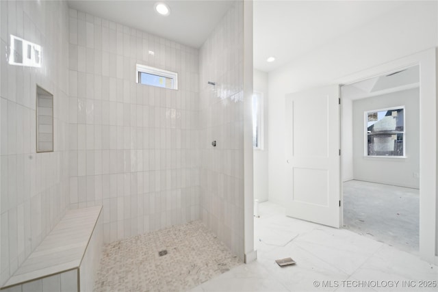 bathroom featuring a healthy amount of sunlight and a tile shower