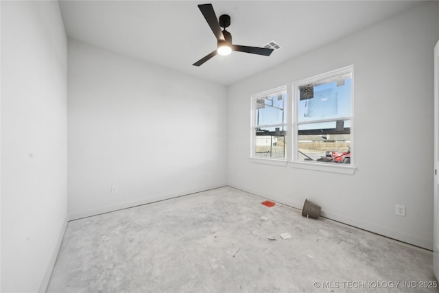 spare room with ceiling fan and concrete floors