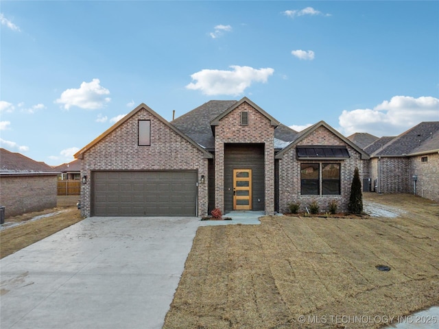 view of front of property featuring brick siding, an attached garage, a front yard, and concrete driveway