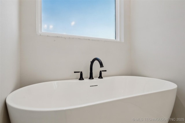 bathroom featuring sink and a washtub