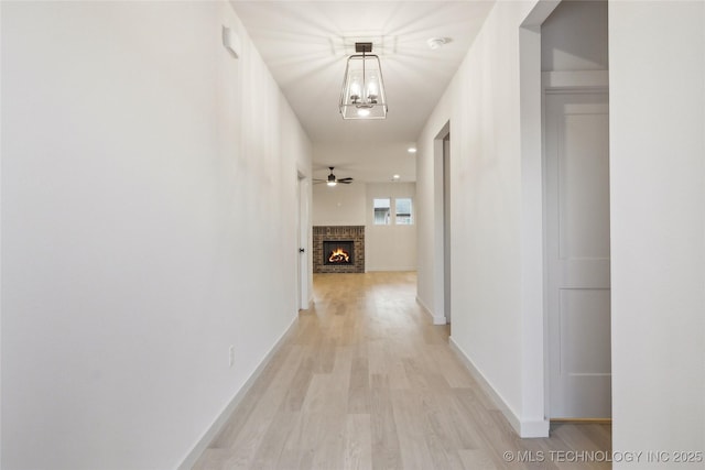 hallway featuring a chandelier and light wood-type flooring