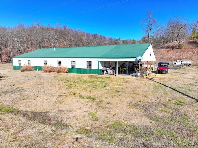 rear view of property with a carport and a yard