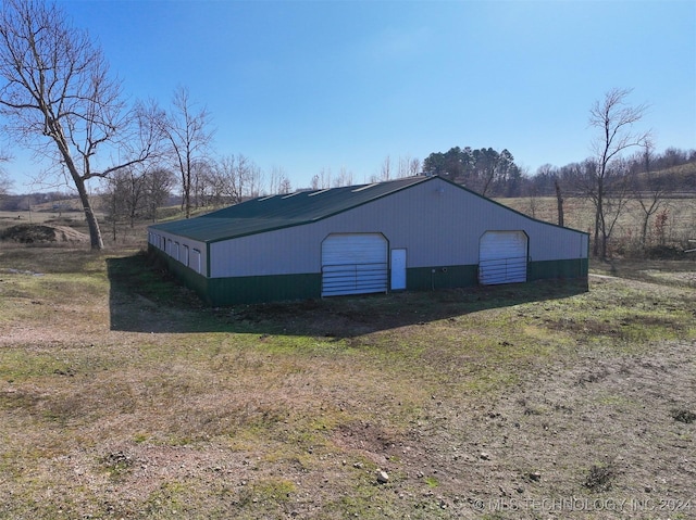 view of outdoor structure featuring a rural view and a garage