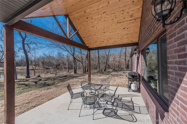 view of patio with area for grilling and a water view