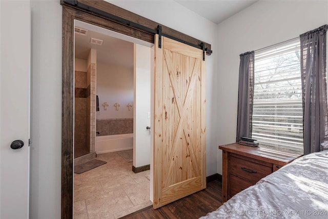 bedroom with connected bathroom and a barn door