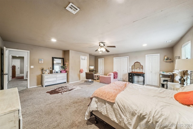 bedroom with multiple closets, ceiling fan, and carpet floors