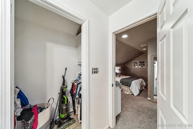 hall with light colored carpet and lofted ceiling