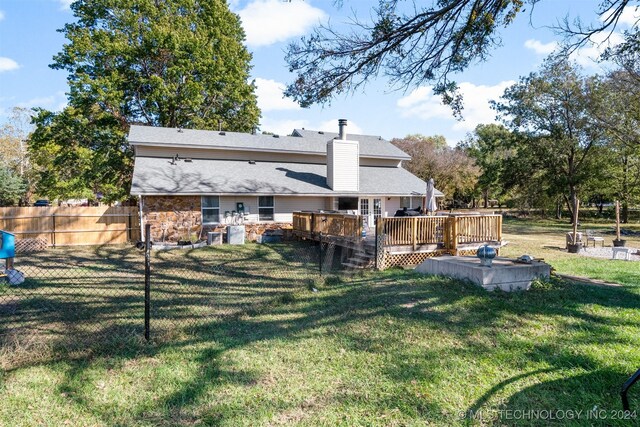 back of property featuring a lawn and a wooden deck