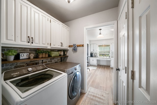 washroom featuring light hardwood / wood-style floors, cabinets, and independent washer and dryer