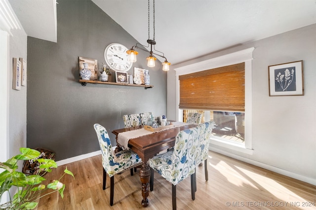 dining space featuring hardwood / wood-style flooring and vaulted ceiling