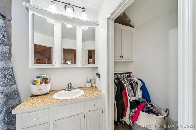 bathroom featuring vanity and lofted ceiling