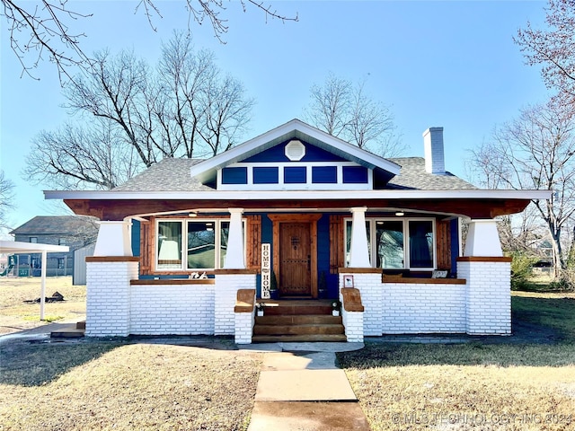 view of front of home with a front yard and covered porch