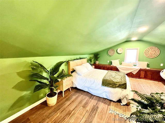 bedroom featuring vaulted ceiling and light wood-type flooring