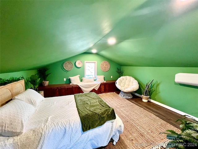 bedroom with wood-type flooring, vaulted ceiling, and a wall mounted AC