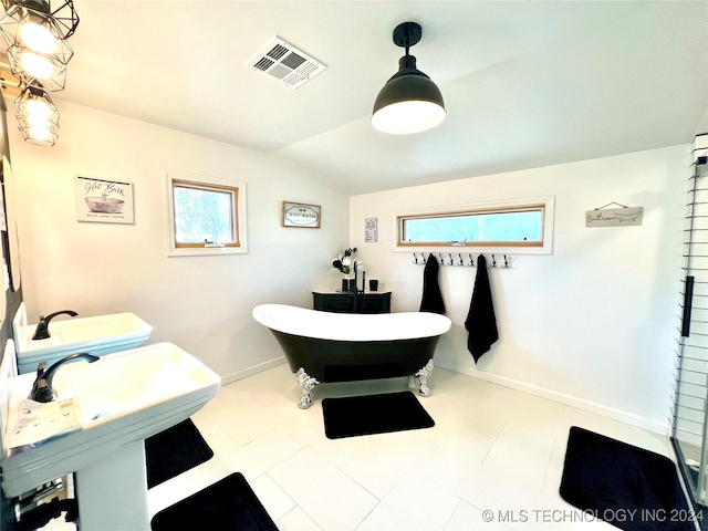 bathroom featuring lofted ceiling, a tub, and sink