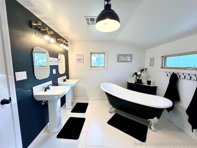 bathroom featuring tile patterned floors, a washtub, and dual sinks