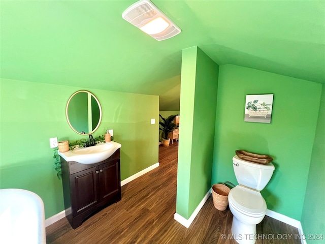 bathroom featuring hardwood / wood-style floors, vanity, vaulted ceiling, and toilet