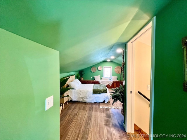 bedroom featuring hardwood / wood-style floors and vaulted ceiling