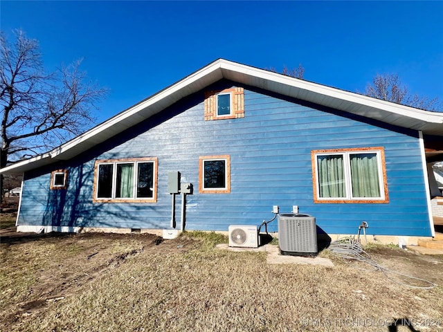 view of side of home with central air condition unit and ac unit